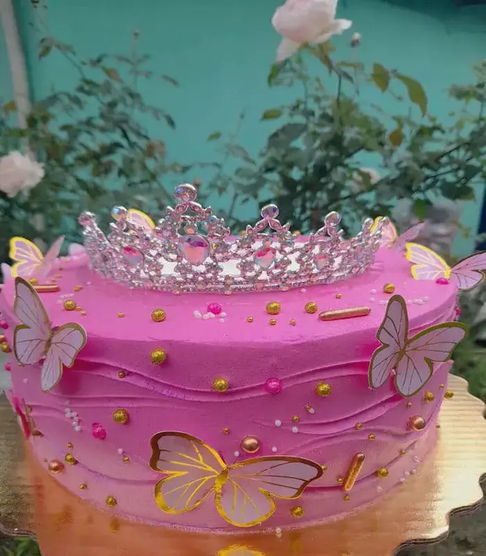 Pastel de Quinceañera con mariposas y coronilla rosa